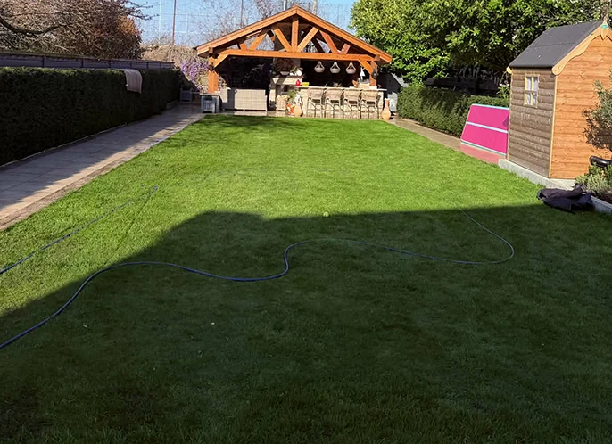 Rasen mit Gartenbewässerung wässern.